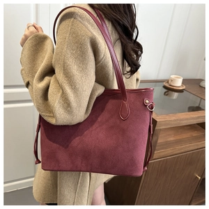 Close-up of burgundy suede tote bag showing premium matte texture and side drawstring detail
