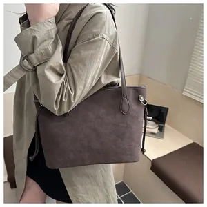 Detailed view of coffee brown suede tote bag with drawstring side ties and long straps