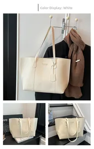 Detail of white large capacity PU leather tote bag with elegant gold embossed lettering