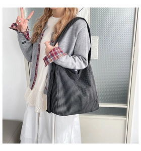Gros plan du sac fourre-tout en toile à carreaux noir et blanc avec large bandoulière
