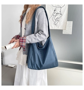 Détail du tissu à carreaux bleu et blanc sur le grand sac à bandoulière spacieux