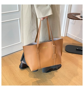 Détail de la texture cuir camel et du logo sur ce grand sac cabas pour femme
