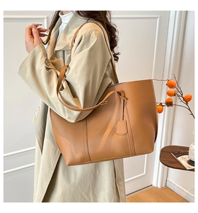 Detail of tan tote bag with FASHION & BAG lettering and long shoulder strap