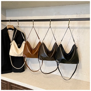 Détail de grands sacs fourre-tout en quatre couleurs sur un présentoir moderne