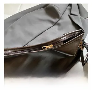 Vue détaillée de la fermeture éclair dorée et du cuir lisse sur le sac cabas marron