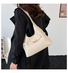 Dettaglio della borsa hobo bianco crema minimalista con fibbia in metallo su cappotto nero