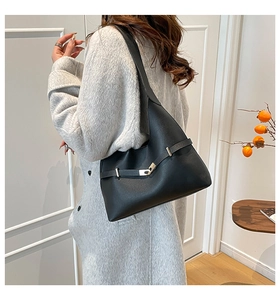 Dettaglio borsa a spalla in pelle nera con fibbia dorata e cinturino elegante