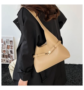 Borsa hobo minimalista in pelle marrone chiaro abbinata a un cappotto nero per uno stile chic