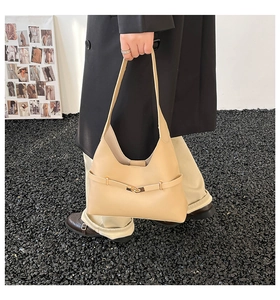 Dettaglio della borsa a mezzaluna color tè al latte con elegante fibbia dorata