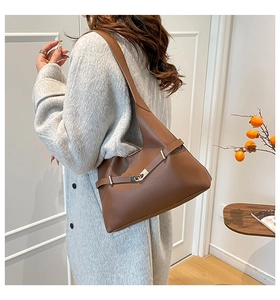 Dettaglio di una grande borsa a tracolla in pelle marrone con elegante fibbia in metallo oro