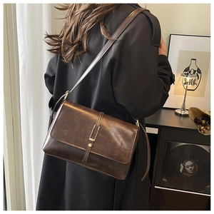 Vue détaillée du sac bandoulière vintage marron foncé avec boucle dorée en métal