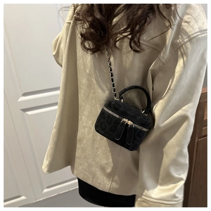 Detailed view of mini leopard print crossbody bucket bag with chain strap and top handle