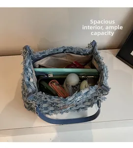 Detail view of denim tote bag showing spacious interior with zipper pocket and quilted texture