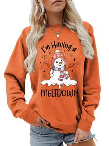 Detail of orange sweatshirt featuring a melting snowman graphic and humorous text