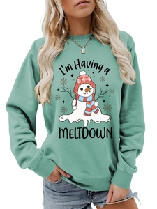 Detailed close-up of snowman print and I'm Having a Meltdown text on green sweatshirt