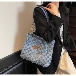 Close-up of distressed denim tote bag with checkerboard weave and frayed edges