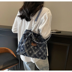 Détail du sac cabas en denim à motif d'étoiles avec bords effilochés et chaîne