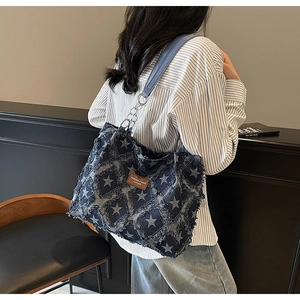 Détail du cabas en denim à motif d'étoiles avec franges et étiquette en cuir marron