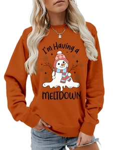 Detail of orange crewneck sweatshirt featuring a cute melting snowman print and festive stars