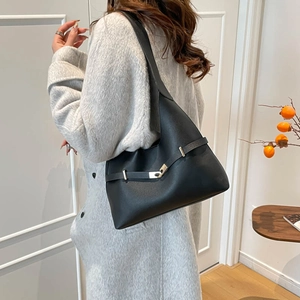 Borsa tote di lusso in pelle nera con fibbia metallica indossata su cappotto grigio