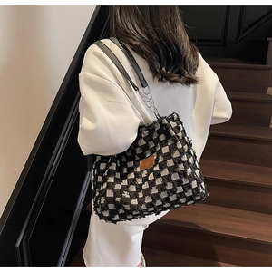 Close-up of checkered tote bag with 3D fringe texture and metal chain strap detail