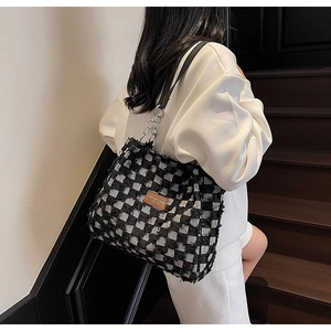 Détail du sac cabas à carreaux avec texture tissée et étiquette en cuir marron