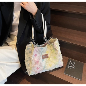 Détail d'un sac cabas en toile avec motifs d'étoiles colorées et écusson en cuir
