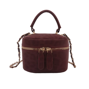 Burgundy suede cylinder crossbody bag with golden chain strap and top handle
