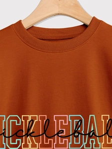 Close-up of crewneck sweatshirt with colorful Pickleball print on orange fabric
