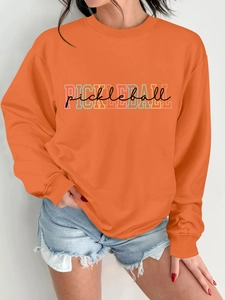 Detail of orange crewneck sweatshirt with colorful Pickleball print and cotton texture