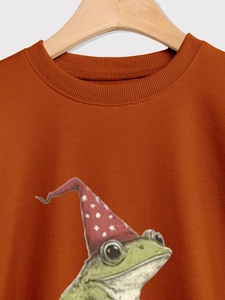 Détail du col rond côtelé sur un sweat orange rouille avec imprimé grenouille magicien