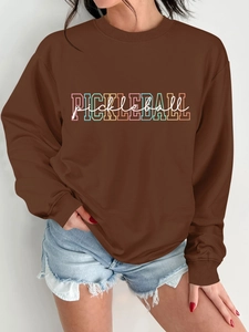 Detail of brown crewneck sweatshirt featuring a colorful PICKLEBALL print on the chest