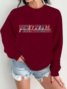 Detail of burgundy crewneck sweatshirt featuring colorful Pickleball print and soft fabric