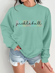 Close-up of mint green crewneck sweatshirt with stylish Pickleball text and denim shorts