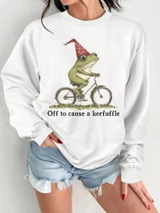 Détail d'un sweat blanc avec une illustration amusante d'un grenouille faisant du vélo
