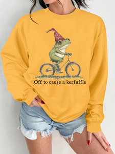 Détail de l'imprimé graphique grenouille à vélo sur un sweat à col rond jaune moutarde