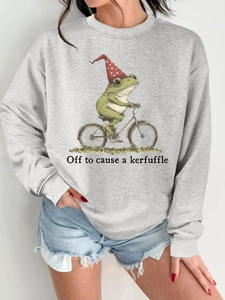Détail d'un sweat gris clair à col rond avec motif grenouille à vélo et texte imprimé