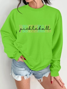 Detail of neon green women's sweatshirt featuring colorful pickleball print and ribbed crewneck