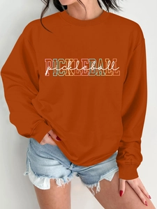 Detail of rust orange Pickleball sweatshirt with ribbed cuffs and multi-color graphic print