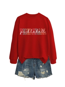 Flat lay of red pickleball sweatshirt with distressed denim shorts on white backdrop