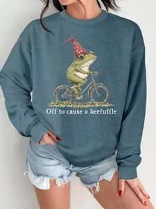 Détail d'un sweat sarcelle avec imprimé grenouille à vélo et texte humoristique blanc