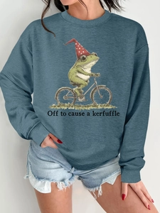Détail d'un sweat bleu avec une illustration amusante d'un grenouille à bicyclette