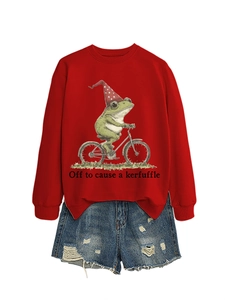 Mise à plat d'un sweat rouge avec illustration de grenouille et short en jean usé