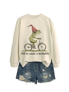 Gros plan du sweat beige avec illustration de grenouille à vélo et texte humoristique