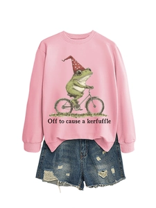 Détail à plat d'un sweat rose avec motif de grenouille drôle et mini short en jean déchiré