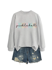 Detail of light grey crewneck sweatshirt with colorful Pickleball print and denim shorts