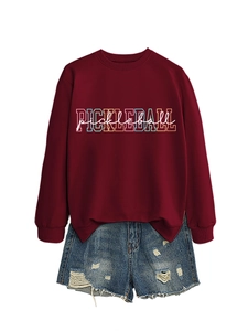 Close-up of a burgundy sweatshirt with colorful Pickleball text and ripped denim shorts