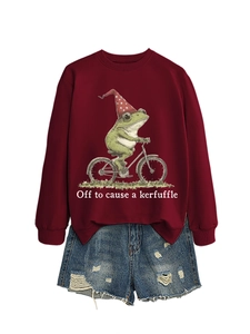 Mise à plat d'un sweat rouge avec imprimé grenouille à vélo et short en jean usé