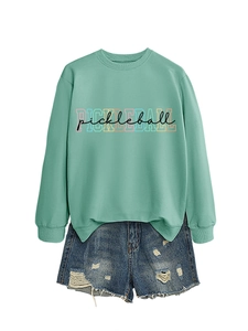 Detail of mint green sweatshirt with colorful Pickleball letters and distressed denim shorts