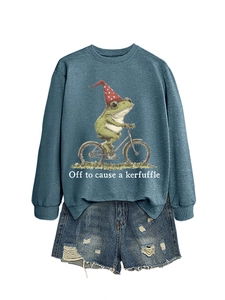 Détail de l'imprimé grenouille à vélo sur un sweat bleu marine avec un short en jean